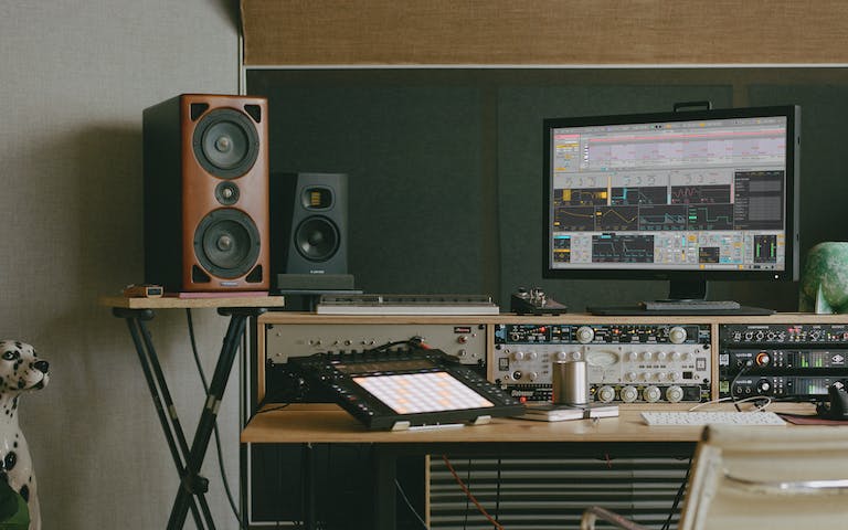 A creative space complete with Push, speakers and a monitor displaying one of Live’s new Stacked Detail Views.