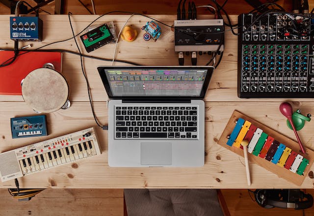 A mixer, percussion instruments and a laptop with Live 11, shot from above